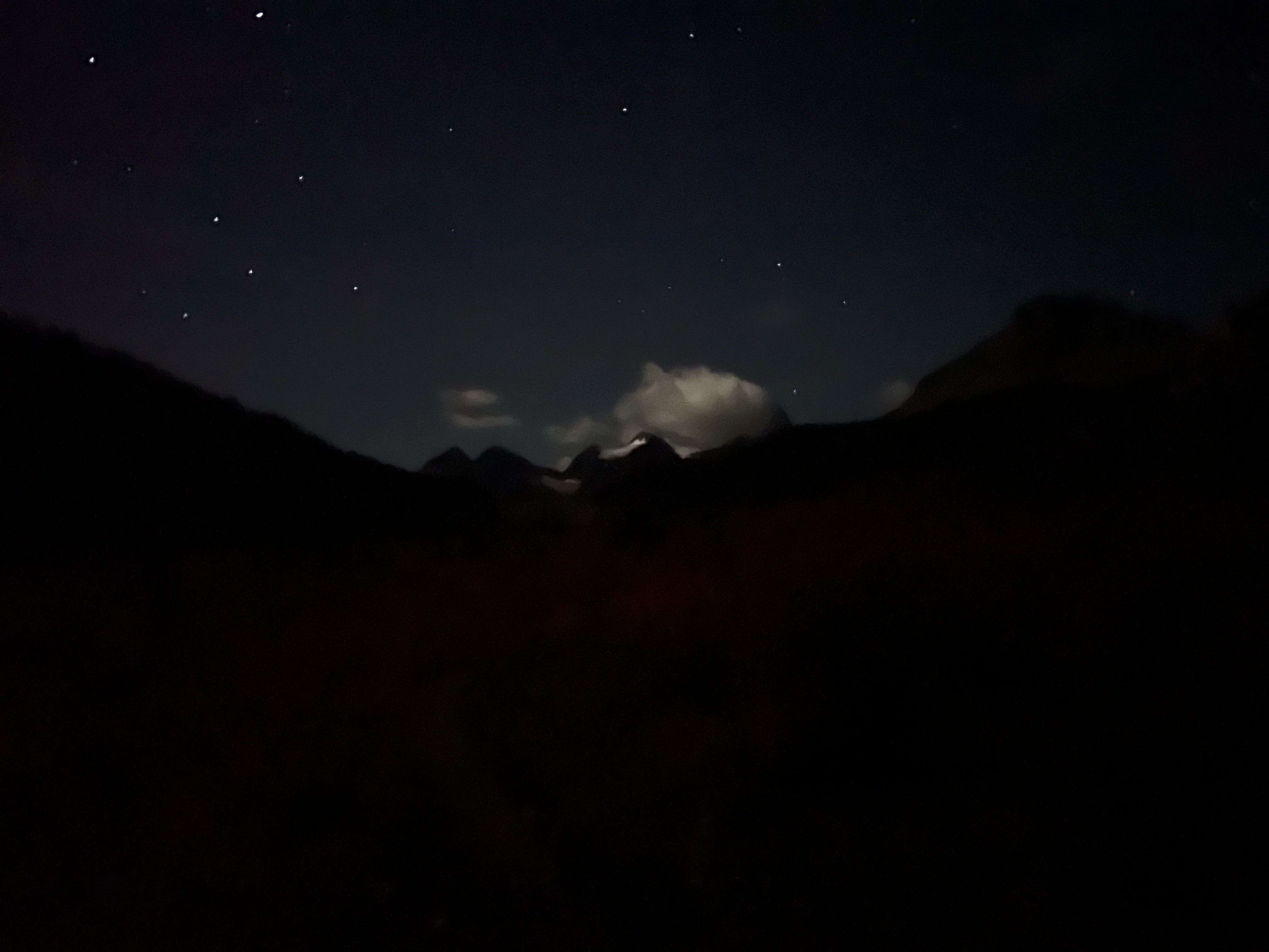 A cloud looms over the dark Mount Assiniboine